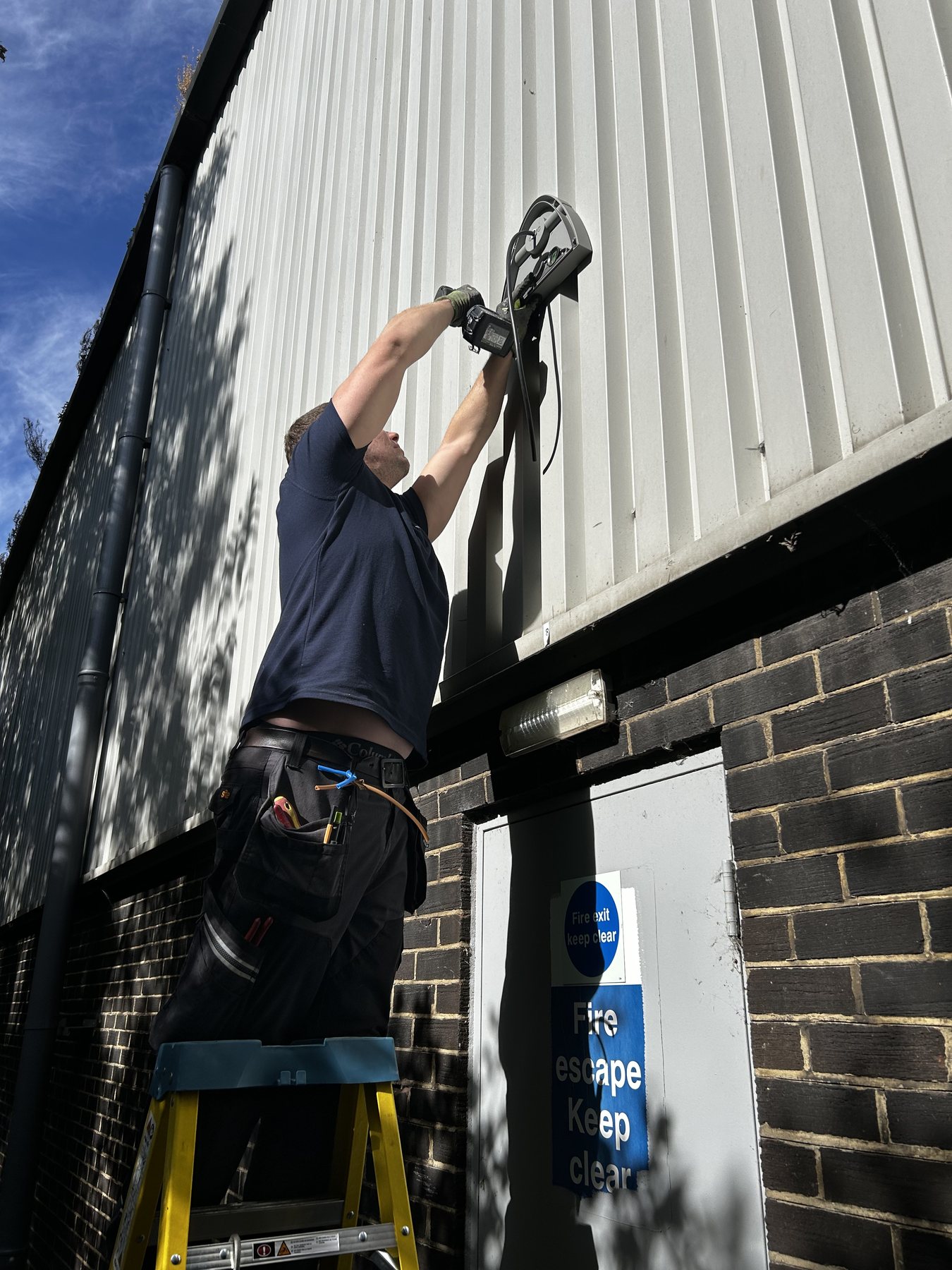 Glenn installing an exterior emergency light at Pikup Padel